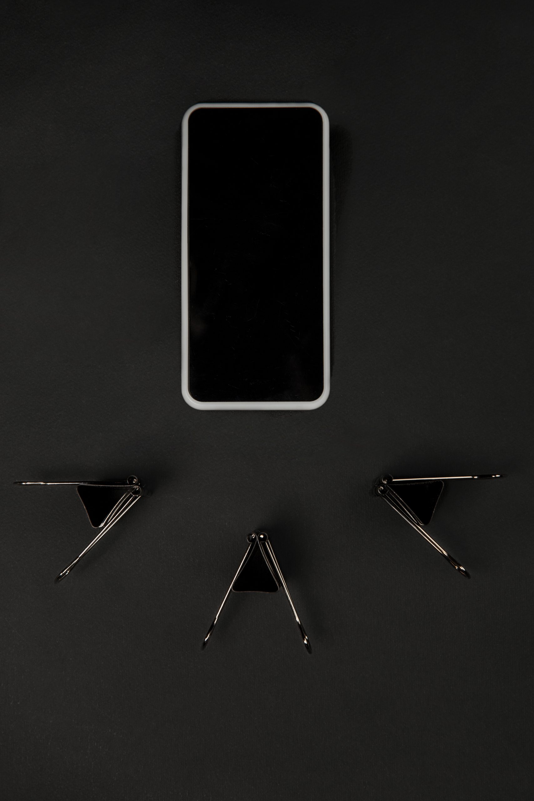 Office. Monochrome stylish and trendy composition in black color on studio background. Top view, flat lay. Pure beauty of usual things around. Copyspace for ad. Close up. Smartphone's blank screen.